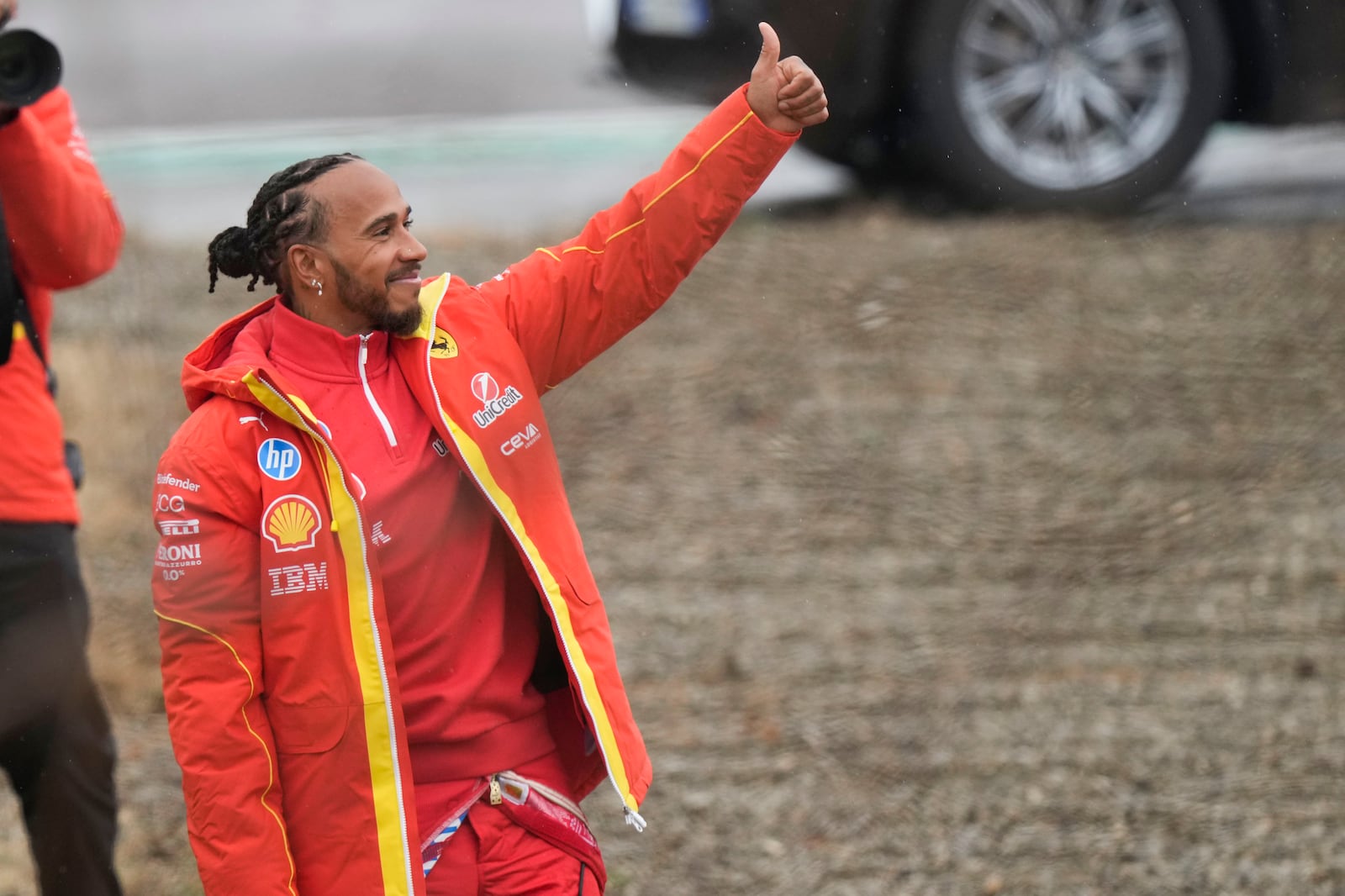 British driver Lewis Hamilton thumbs up to Ferrari fans gathered outside the track, after testing a Ferrari Formula One SF-23, in Fiorano Modenese, Italy, Wednesday, Jan.22, 2025. (AP Photo/Luca Bruno)