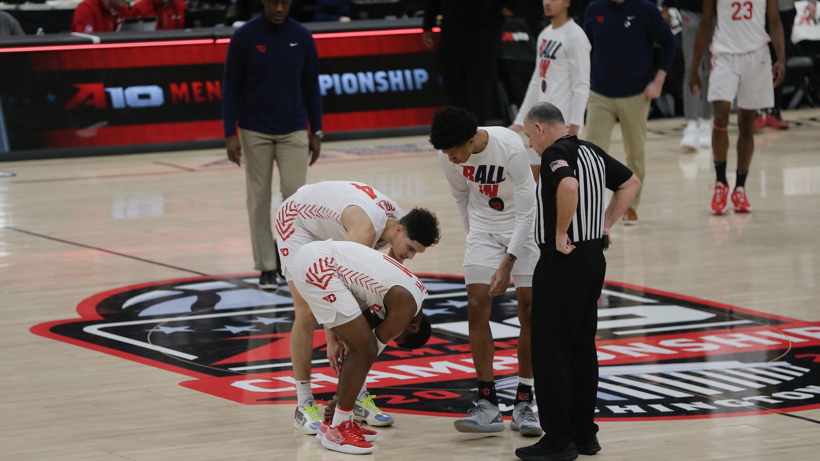 Teammates attend to Dayton's Malachi Smith after he suffered an injury on the final play of the first half against Richmond in the semifinals of the Atlantic 10 Conference tournament on Saturday, March 12, 2022, at Capital One Arena in Washington, D.C. David Jablonski/Staff