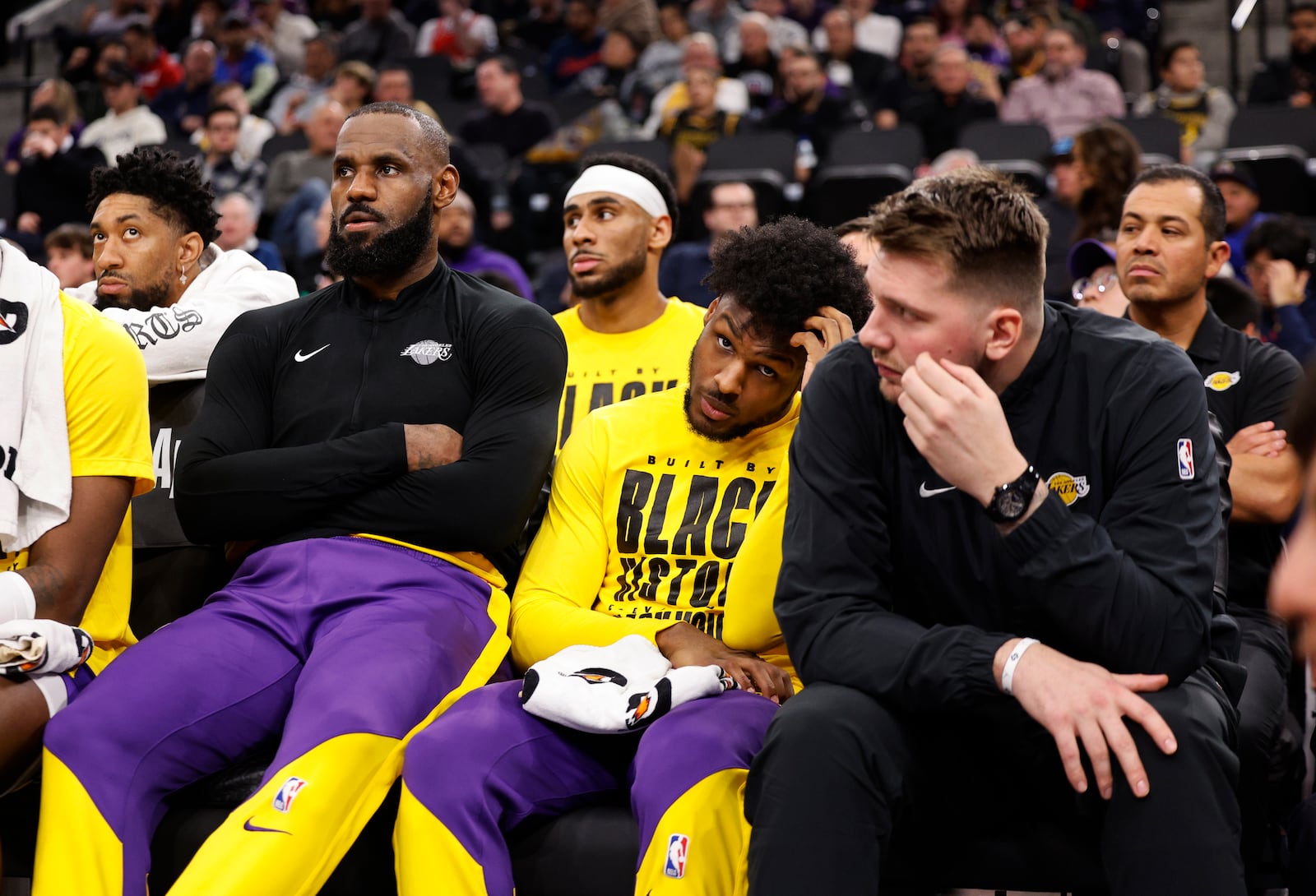 From left, Los Angeles Lakers forward LeBron James, guards Bronny James and Luka Doncic watch from the bench during an NBA basketball game against the Los Angeles Clippers, Tuesday, Feb. 4, 2025, in Inglewood, Calif. (AP Photo/Kevork Djansezian)