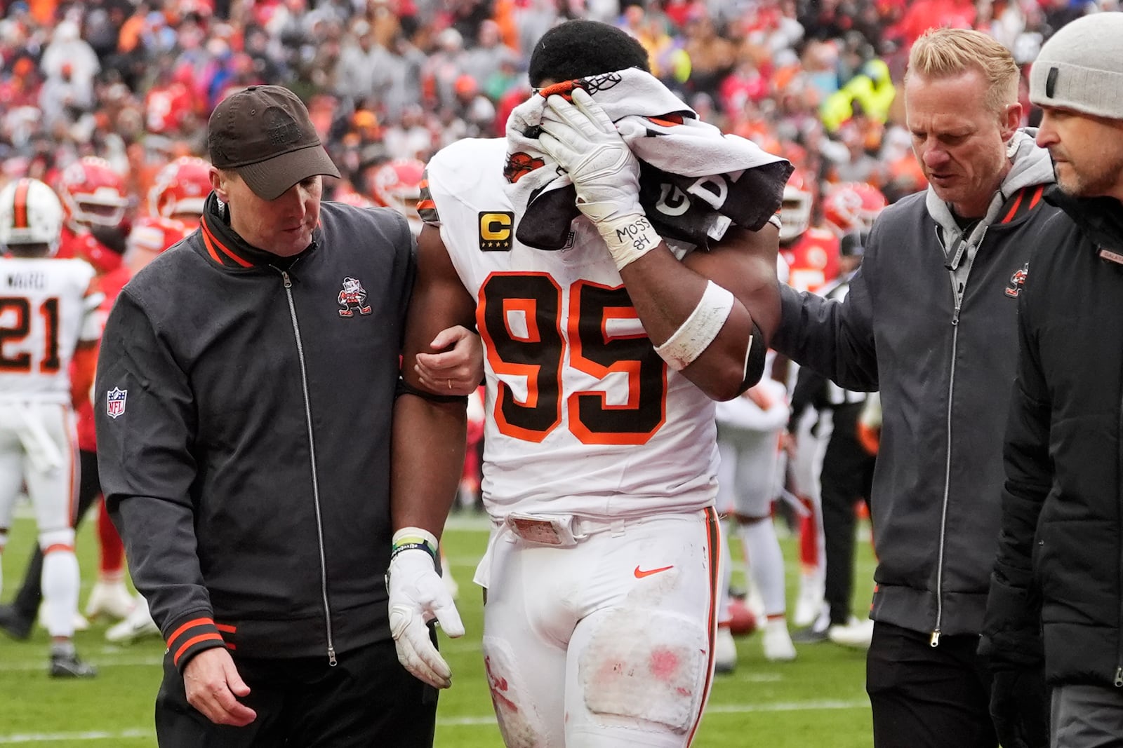 Cleveland Browns defensive end Myles Garrett (95) holds a towel to his face as he is helped off the field after an injury to his eye in the first half of an NFL football game against the Kansas City Chiefs in Cleveland, Sunday, Dec. 15, 2024. Garrett returned to the game. (AP Photo/Sue Ogrocki)