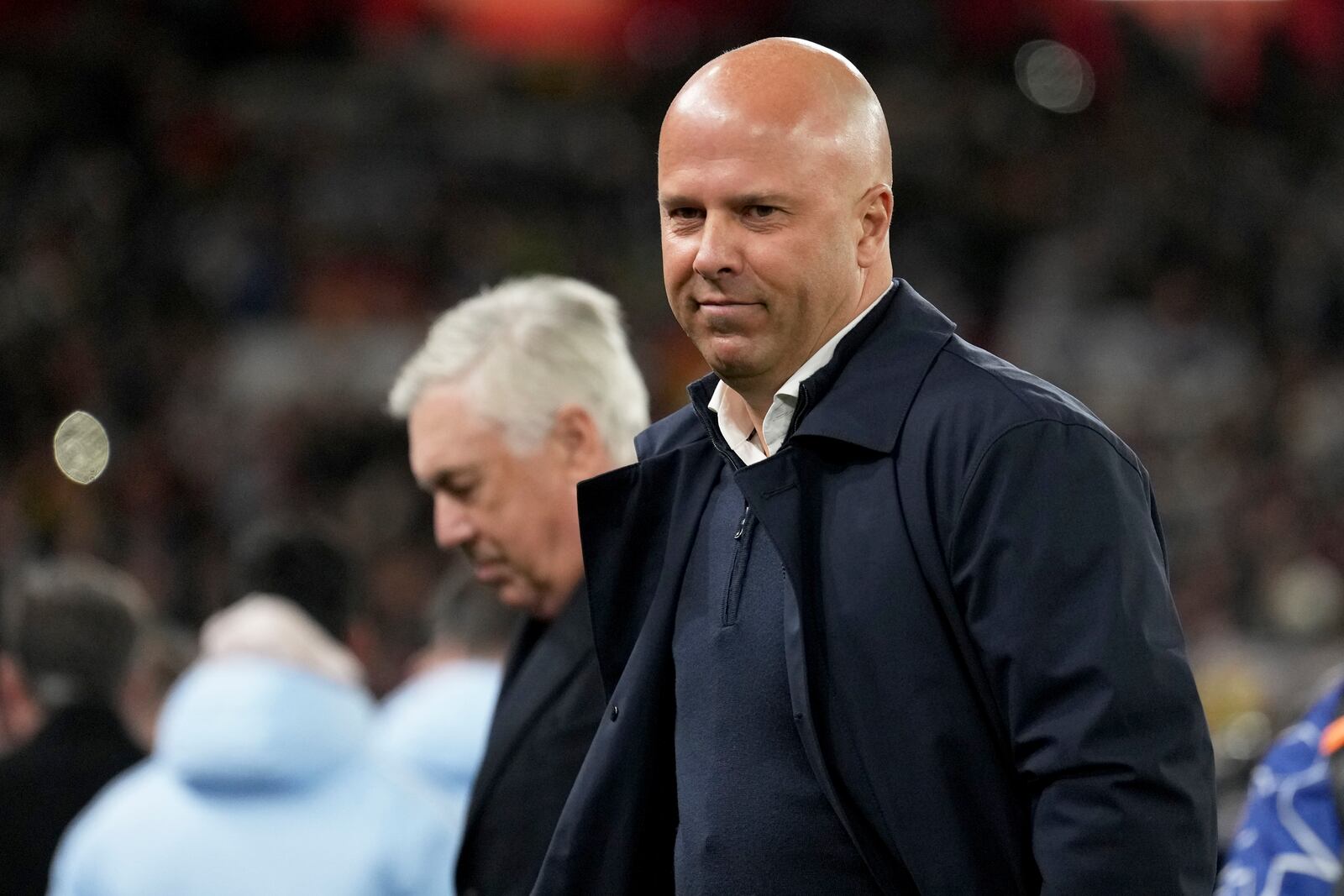 Liverpool's manager Arne Slot and Real Madrid's head coach Carlo Ancelotti, in the background, stand by the touchline before the Champions League opening phase soccer match between Liverpool and Real Madrid at Anfield Stadium, Liverpool, England, Wednesday, Nov. 27, 2024. (AP Photo/Jon Super)