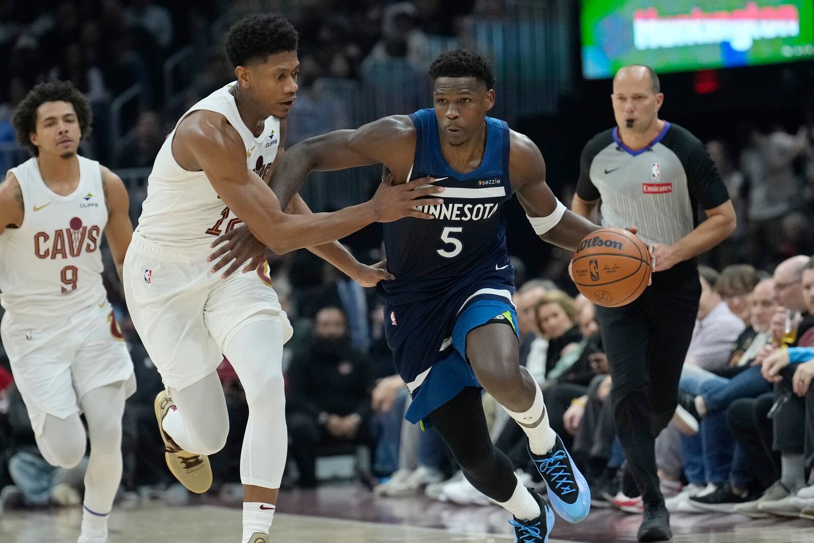 Minnesota Timberwolves guard Anthony Edwards (5) drives upcourt with Cleveland Cavaliers forward De'Andre Hunter, second from left, in the first half of an NBA basketball game Monday, Feb. 10, 2025, in Cleveland. (AP Photo/Sue Ogrocki)