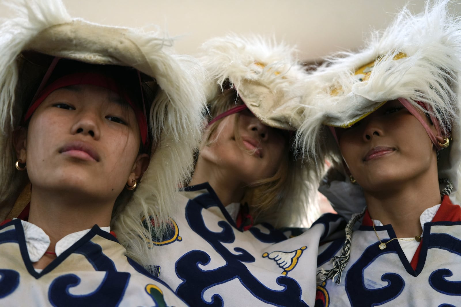 Young dancers in bearded masks pose for a photo before performing a dance to wish luck to U.S.-born Buddhist lama Jalue Dorje during his 18th birthday and enthronement ceremony in Isanti, Minn., on Saturday, Nov. 9, 2024. (AP Photo/Luis Andres Henao)