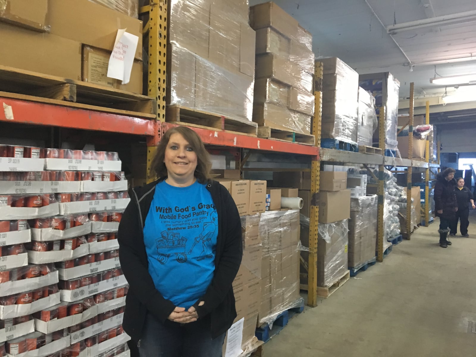 Nicole Adkins stands inside With God’s Grace’s warehouse on Springfield Street in east Dayton. CORNELIUS FROLIK / STAFF