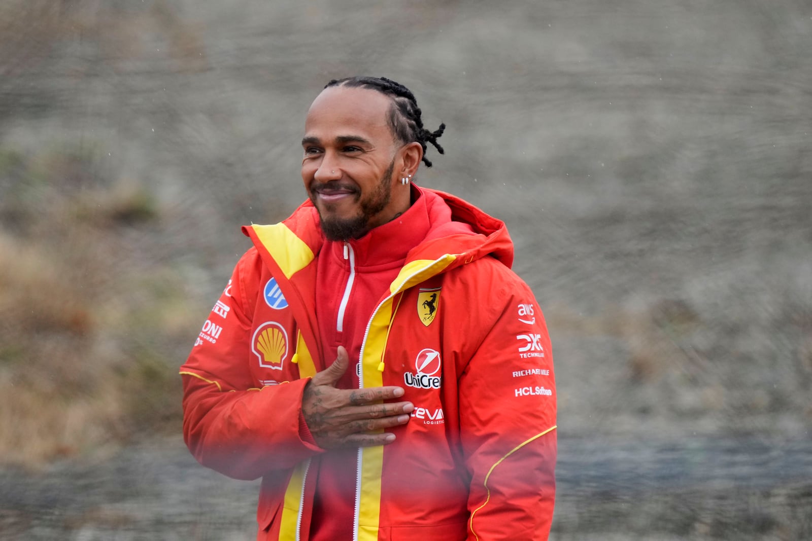 British driver Lewis Hamilton cheers Ferrari fans gathered outside the track, after testing a Ferrari Formula One SF-23, in Fiorano Modenese, Italy, Wednesday, Jan.22, 2025. (AP Photo/Luca Bruno)