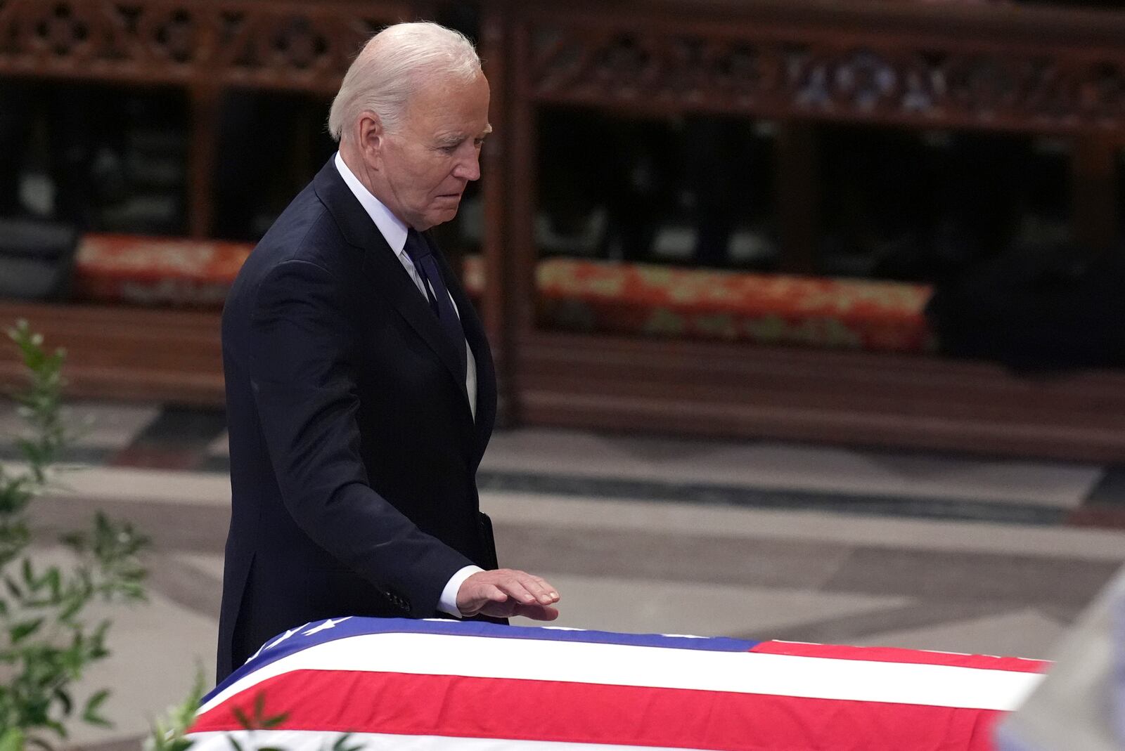 President Joe Biden touches the casket of former President Jimmy Carter during a state funeral service at Washington National Cathedral in Washington, Thursday, Jan. 9, 2025. (AP Photo/Jacquelyn Martin)