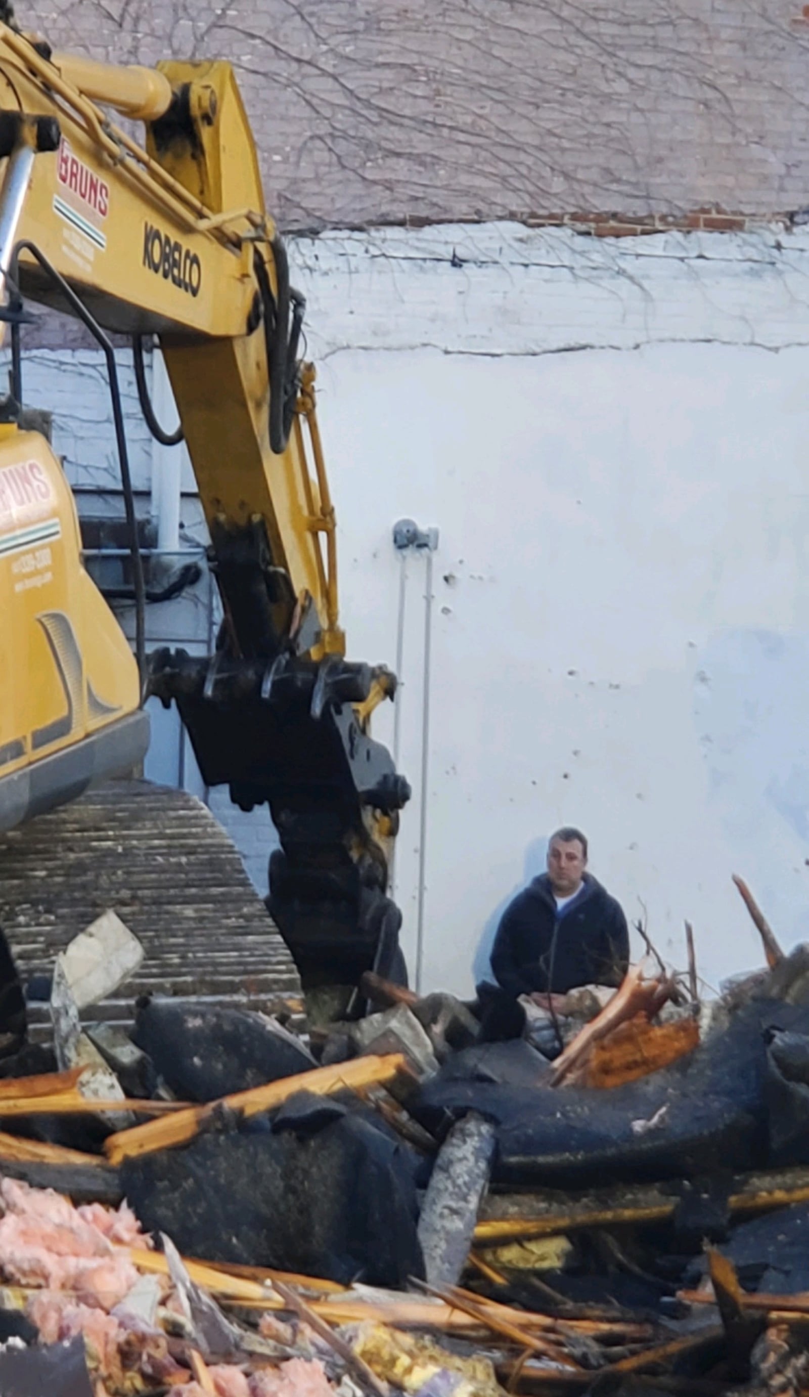 Troy Historic Preservation Alliance member Ben Sutherly stands in front of a bulldozer at the Troy Tavern building on Wednesday morning, March 29, 2023. CONTRIBUTED PHOTO