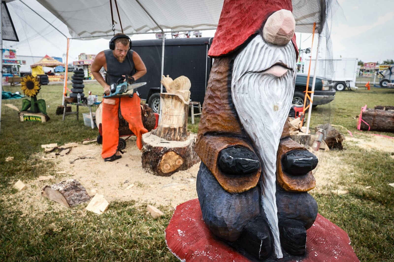 Germantown native Nick Smith carves a snail at the Montgomery County Fair Wednesday July 10, 2024. Smith travels around the county carving wooden figures and selling them, mostly at County Fairs. His both is called Chainsaw Art by Nick and Amanda Smith. JIM NOELKER/STAFF