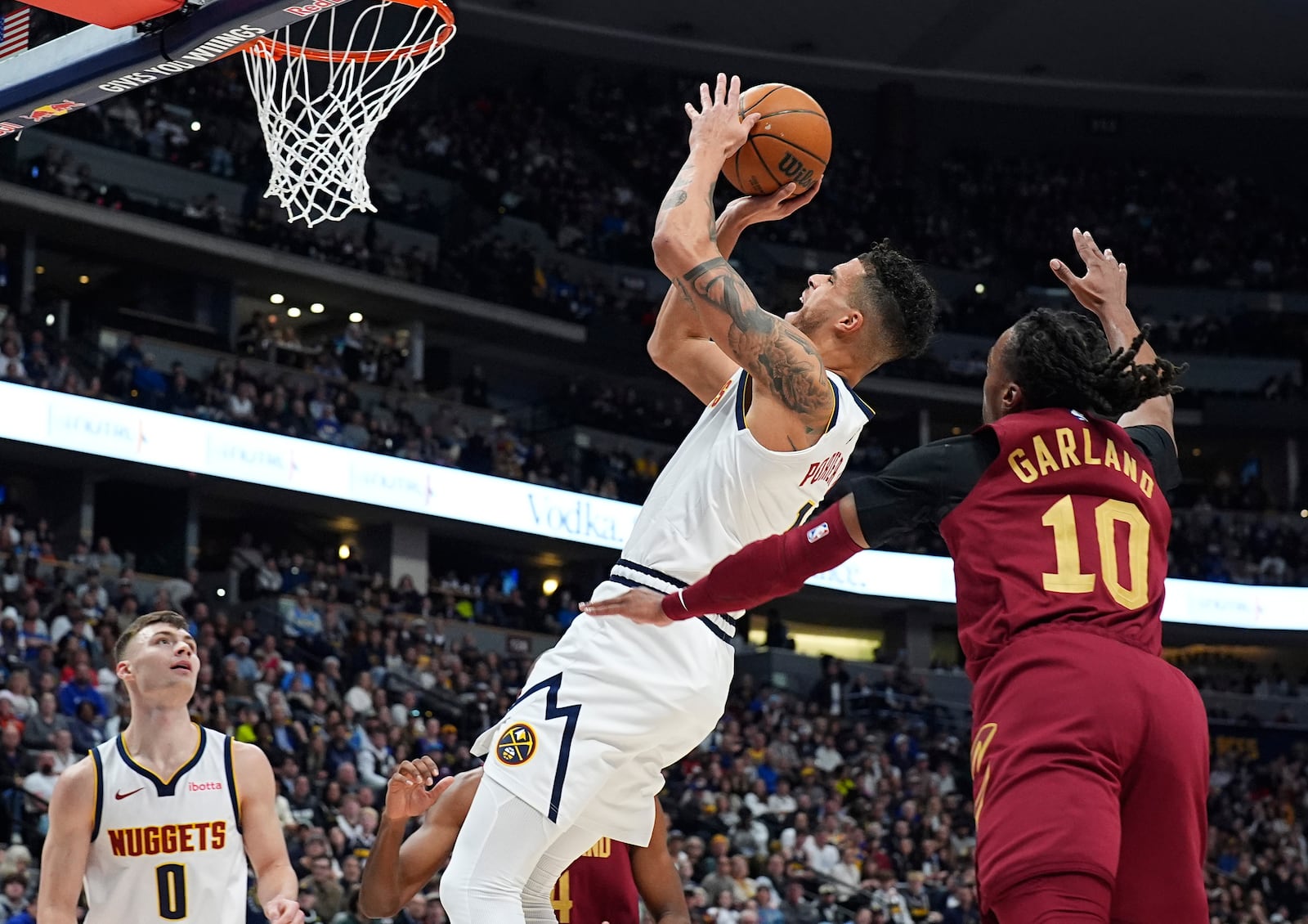 Denver Nuggets forward Michael Porter Jr., left, is fouled as he drives to the basket by Cleveland Cavaliers guard Darius Garland in the first half of an NBA basketball game Friday, Dec. 27, 2024, in Denver. (AP Photo/David Zalubowski)