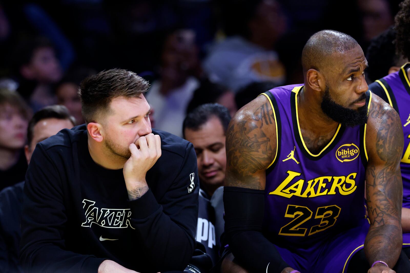 Los Angeles Lakers guard Luka Doncic, left, and forward LeBron James, right, follow the action on the floor from the bench during the first half of an NBA basketball game against the Golden State Warriors, Thursday, Feb. 6, 2025, in Los Angeles. (AP Photo/Kevork Djansezian)