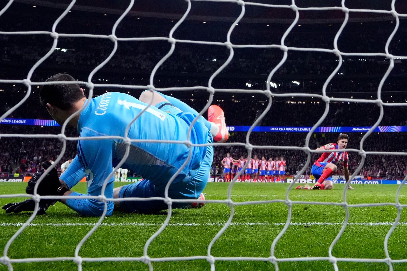 Atletico Madrid's Julian Alvarez, right, stands up after falling to the ground when taking a penalty kick during a shootout at the end of the Champions League round of 16, second leg, soccer match between Atletico Madrid and Real Madrid at the Metropolitano stadium in Madrid, Spain, Wednesday, March 12, 2025. (AP Photo/Manu Fernandez)