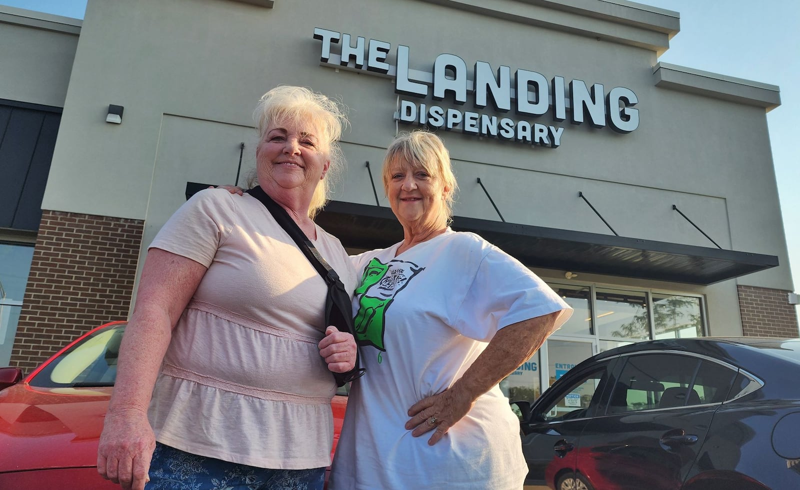 Becky Vliege, left, and Carey Farmer, from Liberty Twp. sat in their car as the first to arrive at The Landing Dispensary in Monroe on Tuesday, Aug. 6, 2024. NICK GRAHAM / STAFF