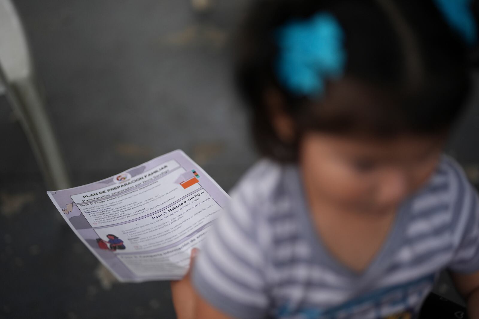 A U.S.-born toddler sits on her mother's lap as Nora Sandigo, who runs a non-profit dedicated to supporting immigrant families, explains migrants' legal rights and options to prepare their families in case a parent were to be detained or deported, Friday, Jan. 17, 2025, in Homestead, Fla. (AP Photo/Rebecca Blackwell)