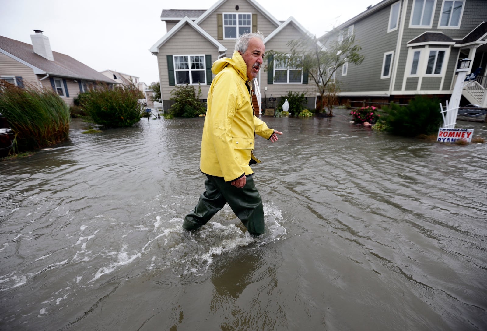 FILE - Richard Thomas walks through the floodwaters in front of his home after assisting neighbors as Hurricane Sandy bears down on the East Coast, Monday, Oct. 29, 2012, in Fenwick Island, Del. (AP Photo/Alex Brandon, File)