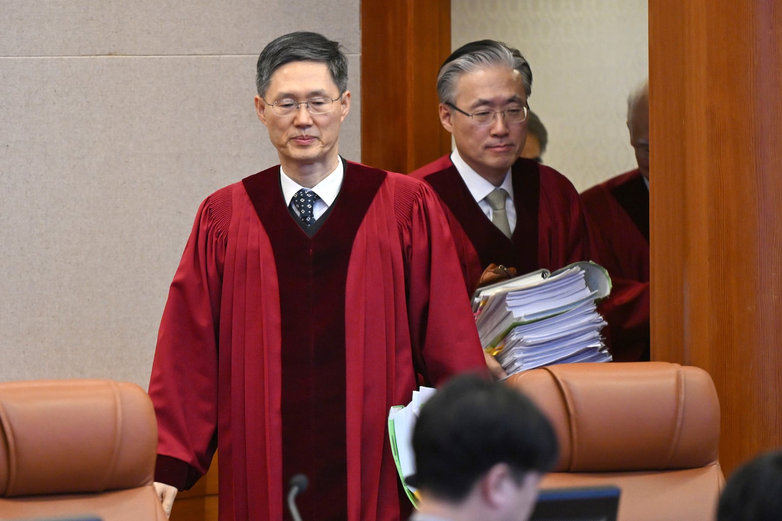 Judge Moon Hyung-bae, acting chief justice of South Korea's Constitutional Court, center left, and other justices arrive at the courtroom for the final hearing over South Korea's impeached President Yoon Suk Yeol's imposition of martial law, at the Constitutional Court in Seoul, South Korea, Tuesday, Feb. 25, 2025. (Jung Yeon-je/Pool Photo via AP)