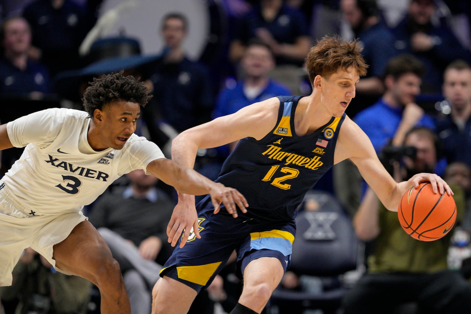 Marquette forward Ben Gold (12) dribbles against Xavier guard Dailyn Swain (3) during the first half of an NCAA college basketball game, Saturday, Dec. 21, 2024, in Cincinnati. (AP Photo/Jeff Dean)