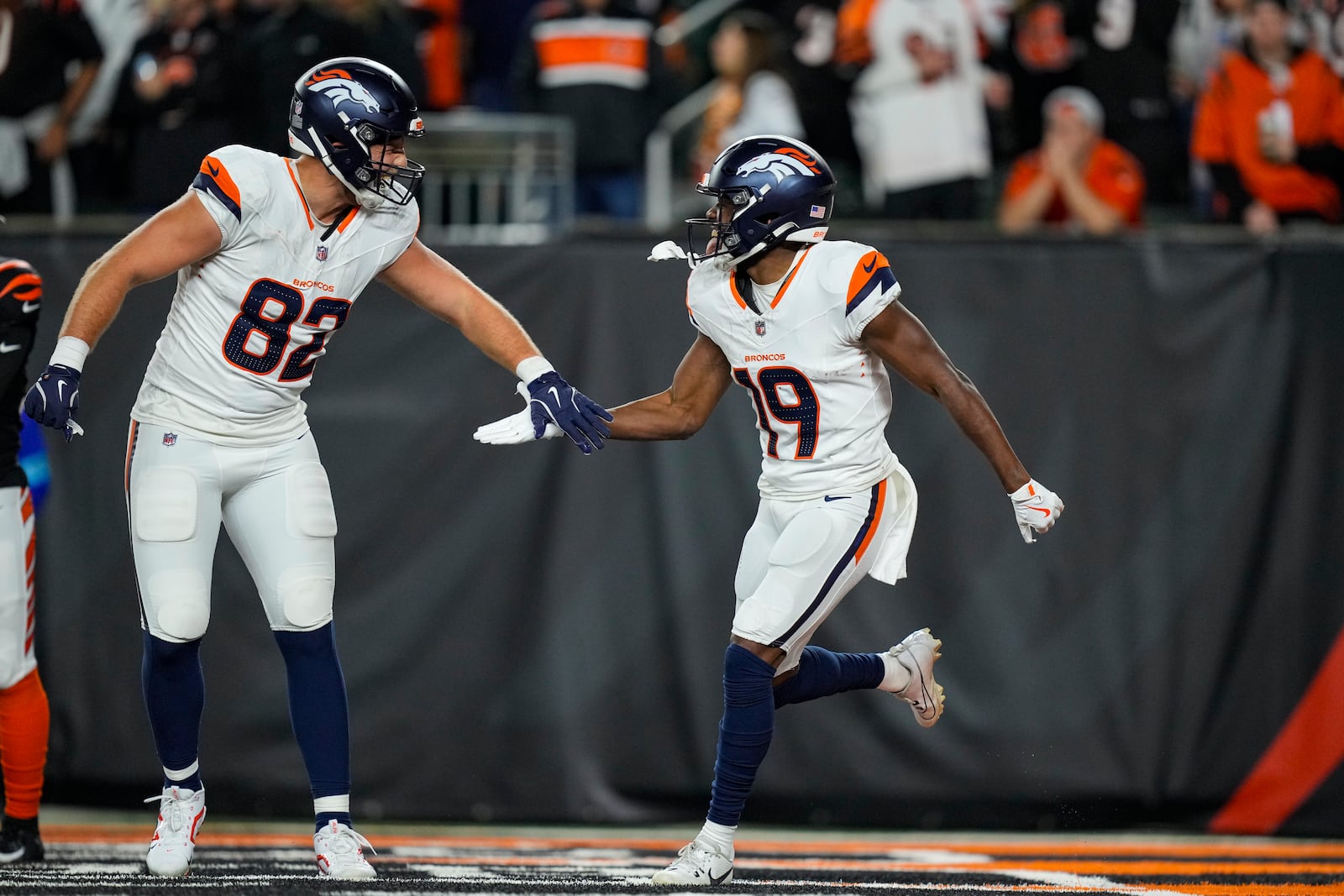 Denver Broncos wide receiver Marvin Mims Jr. (19) celebrates a touchdown with tight end Adam Trautman (82) against the Cincinnati Bengals during the second half of an NFL football game in Cincinnati, Saturday, Dec. 28, 2024. (AP Photo/Carolyn Kaster)