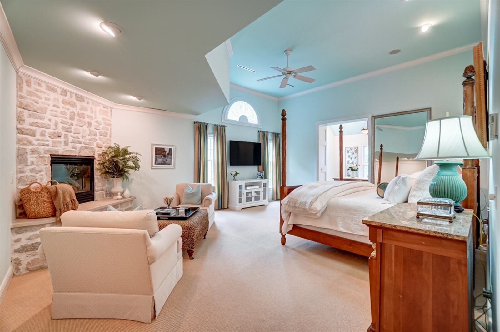 The primary bedroom features a sitting area with a corner stone fireplace. 