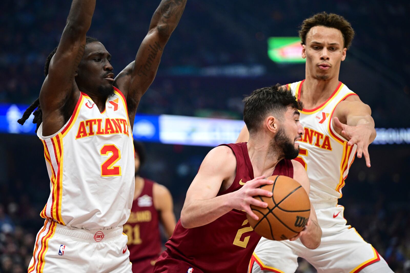 Cleveland Cavaliers guard Ty Jerome, center, dribbles away from Atlanta Hawks guards Dyson Daniels, right, and Keaton Wallace (2) in the first half of an NBA basketball game, Thursday, Jan. 30, 2025, in Cleveland. (AP Photo/David Dermer)