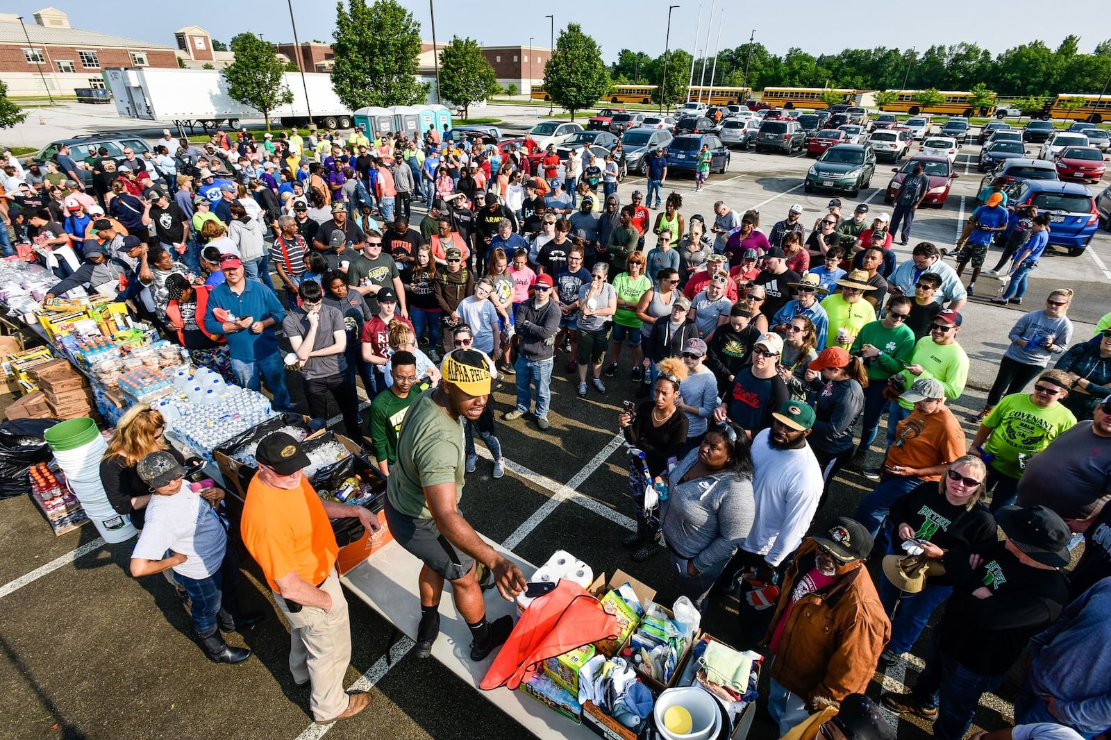 Frederick Cox, coordinator of the Trotwood site for Living City Project, gives instructions to community cleanup volunteers on Saturday at Trotwood-Madison High School before they were bused to Trotwood neighborhood damaged in Monday s tornado. NICK GRAHAM/STAFF PHOTO