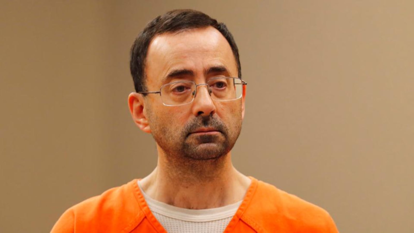 FILE - In this Nov. 22, 2017, file photo, Dr. Larry Nassar, appears in court for a plea hearing in Lansing, Mich. Nassar, an elite Michigan sports doctor who possessed child pornography and assaulted gymnasts, was sentenced Thursday, Dec. 7, 2017,  to 60 years in federal prison in one of three criminal cases that ensure he will never be free again. (AP Photo/Paul Sancya, File)