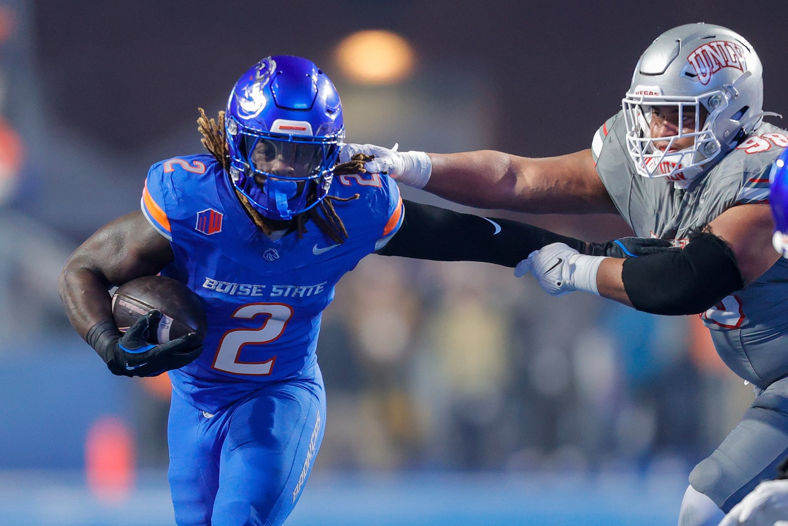 Boise State running back Ashton Jeanty (2) pushes away from the arms of UNLV defensive lineman Tatuo Martinson (98) on a run in the first half of the Mountain West Championship NCAA college football game Friday, Dec. 6, 2024, in Boise, Idaho. (AP Photo/Steve Conner)