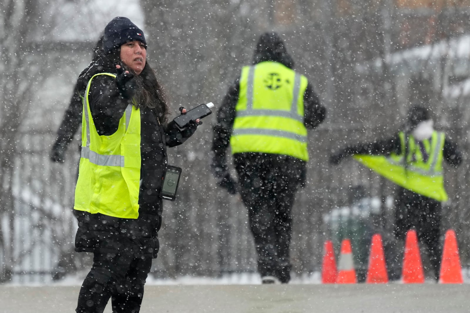 Parking attendants wait to help drivers at a Northwestern University parking lot during a snow day in Evanston, Ill., Sunday, Jan. 12, 2025. (AP Photo/Nam Y. Huh)