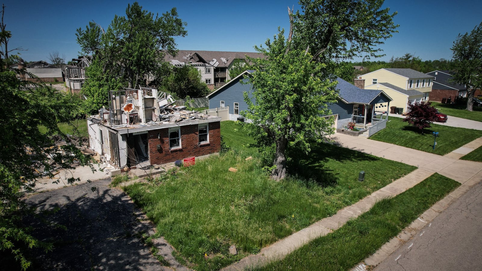 Homeowners struggled following the 2019 Memorial Day tornadoes. On Trotwood's Greenbrook Drive in May 2022, beautifully rehabbed houses are neighbors to a destroyed, vacant home. JIM NOELKER/STAFF