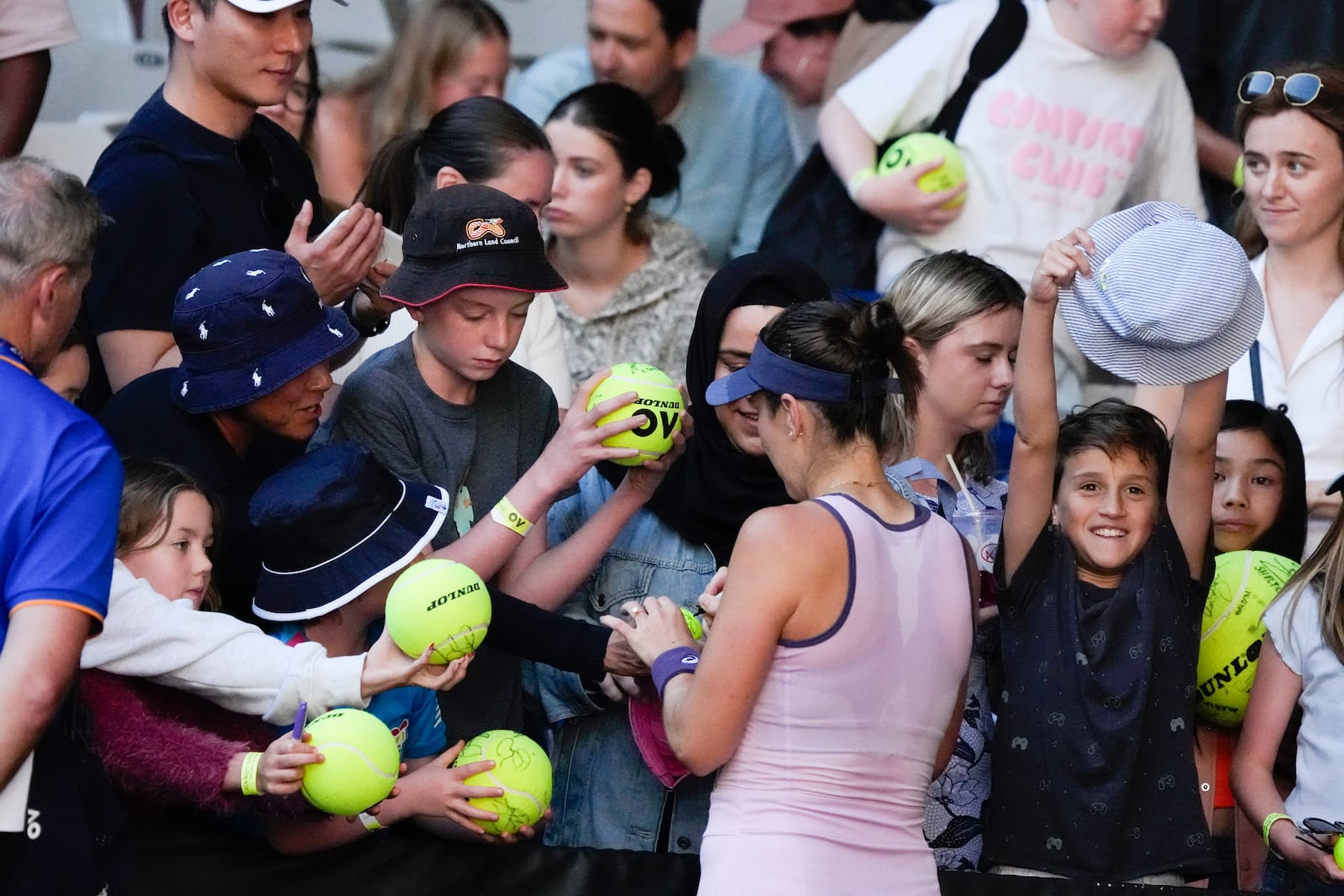 Belinda Bencic of Switzerland signs autographs following her third round match against Naomi Osaka of Japan at the Australian Open tennis championship in Melbourne, Australia, Friday, Jan. 17, 2025. (AP Photo/Manish Swarup)