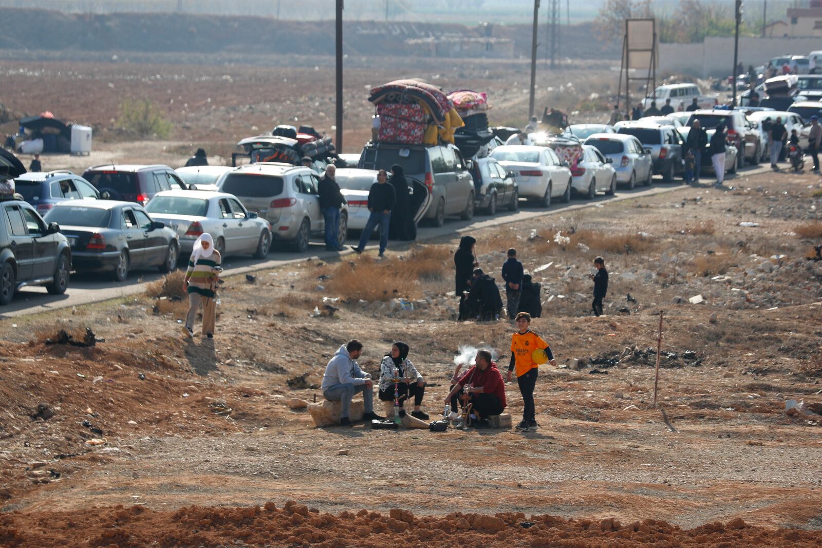 Lebanese families sit in traffic as they return to Lebanon through the Jousieh border crossing, in Qusair, Syria, Thursday, Nov. 28, 2024, following a ceasefire between Israel and Hezbollah that went into effect on Wednesday. (AP Photo/Omar Sanadiki)