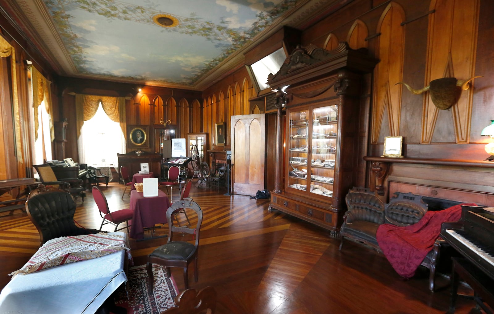 Easter fun will take place in the drawing room Sunday. Margaret Piatt calls this room at Mac-A-Cheek “the best room with the best things in it.” It was the original portion of the home that opened as a museum in 1912. A massive cabinet filled with natural history treasures collected by William McCoy Piatt is at right. LISA POWELL / STAFF