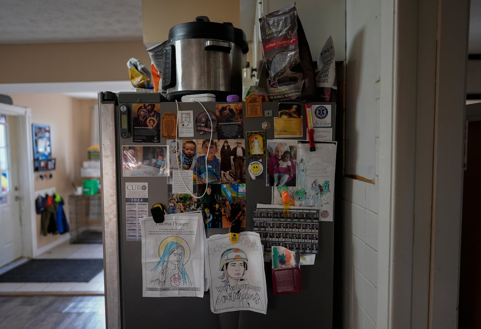 The refrigerator is decorated with family photos, prayers, and drawings in the Young's Sunbury, Ohio, kitchen on Tuesday, Nov. 12, 2024. (AP Photo/Carolyn Kaster)