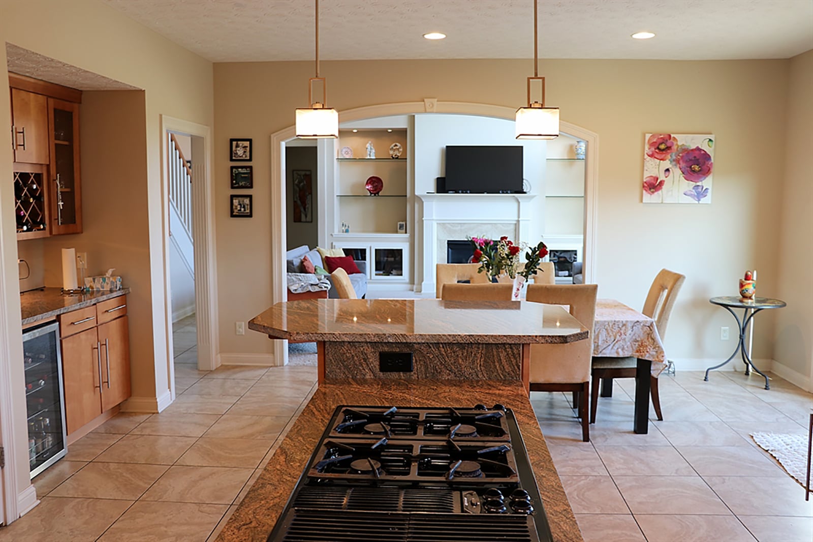 The kitchen’s lower counter has a gas cooktop with grill. A fluted, wood-trimmed arched walkway leads from the great room into the combination breakfast room and kitchen. CONTRIBUTED PHOTO BY KATHY TYLER