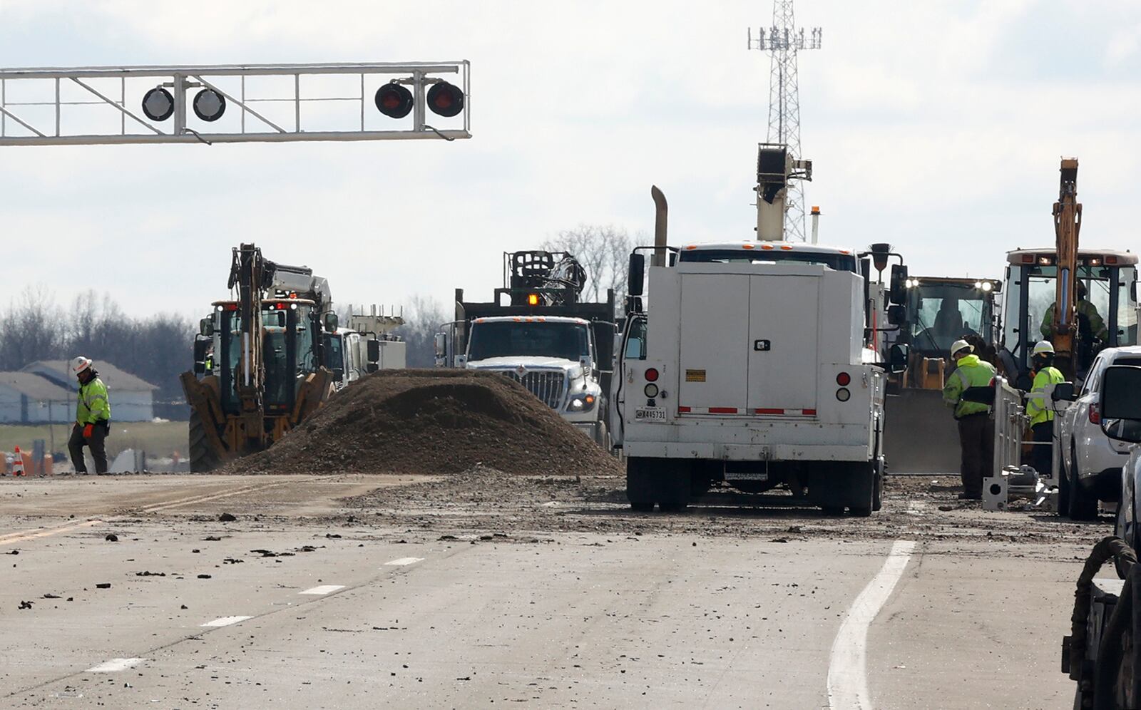 Work continues on the Ohio Route 41 railroad crossing Tuesday, March 7, 2023. The roadway was severely damaged when the train derailed Saturday. BILL LACKEY/STAFF