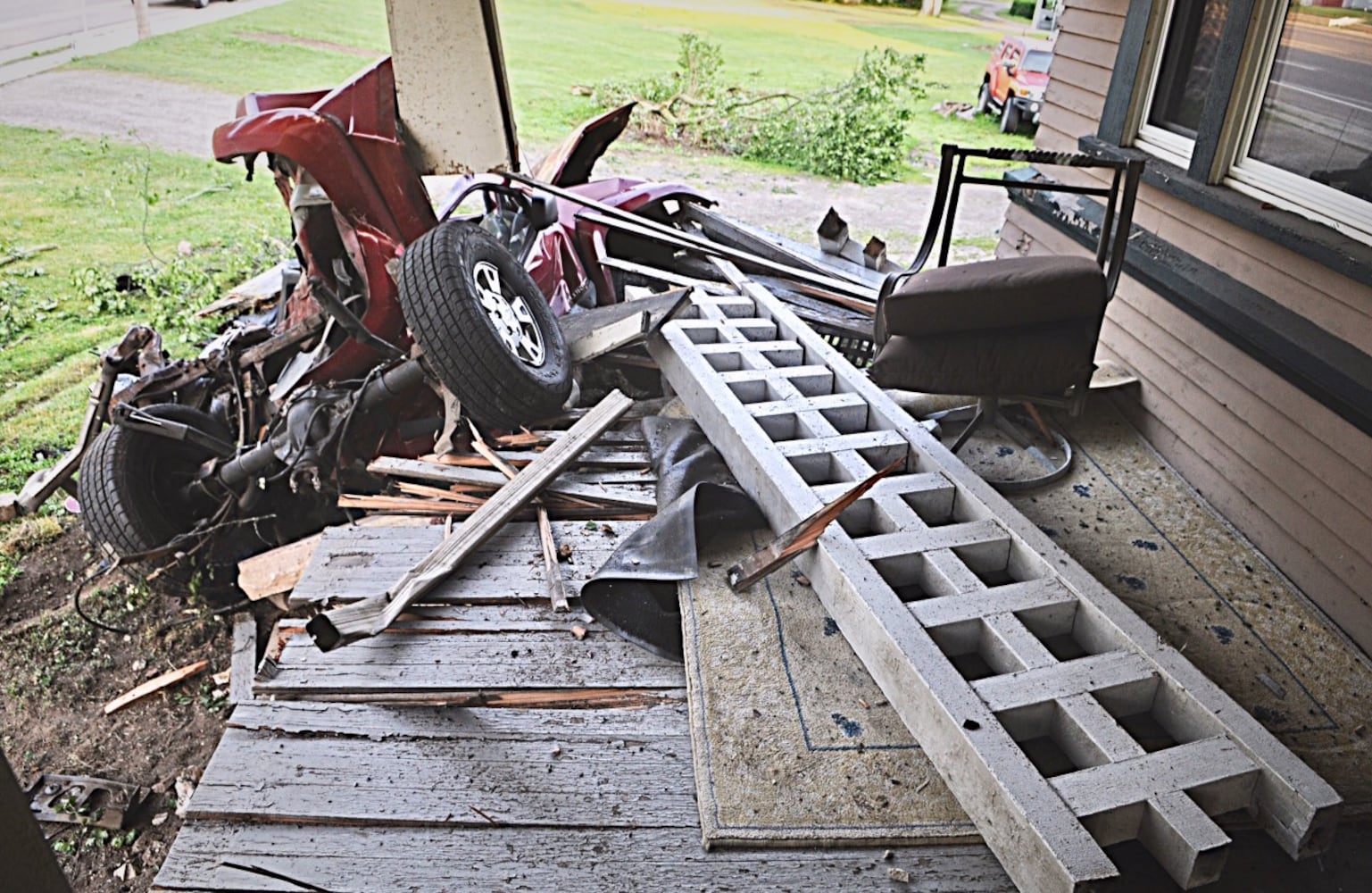 Tanker truck strikes pole, porch, other cars