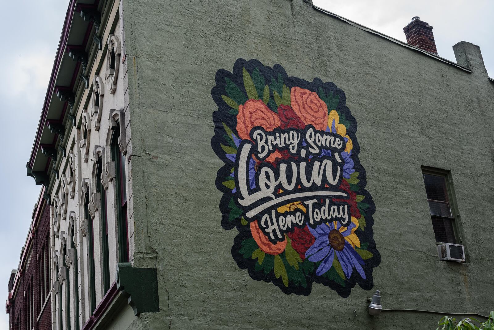 Artists Atalie Gagnet and Tiffany Clark painted the "Bring Some Lovin' Here Today" mural outside of Blind Bob's in the Oregon District. The mural was inspired by John Legend’s cover of Marvin Gaye’s “What’s Going On?” at Blind Bob’s in a special private performance. The singer visited the historic neighborhood a week after the mass shooting. TOM GILLIAM/CONTRIBUTED