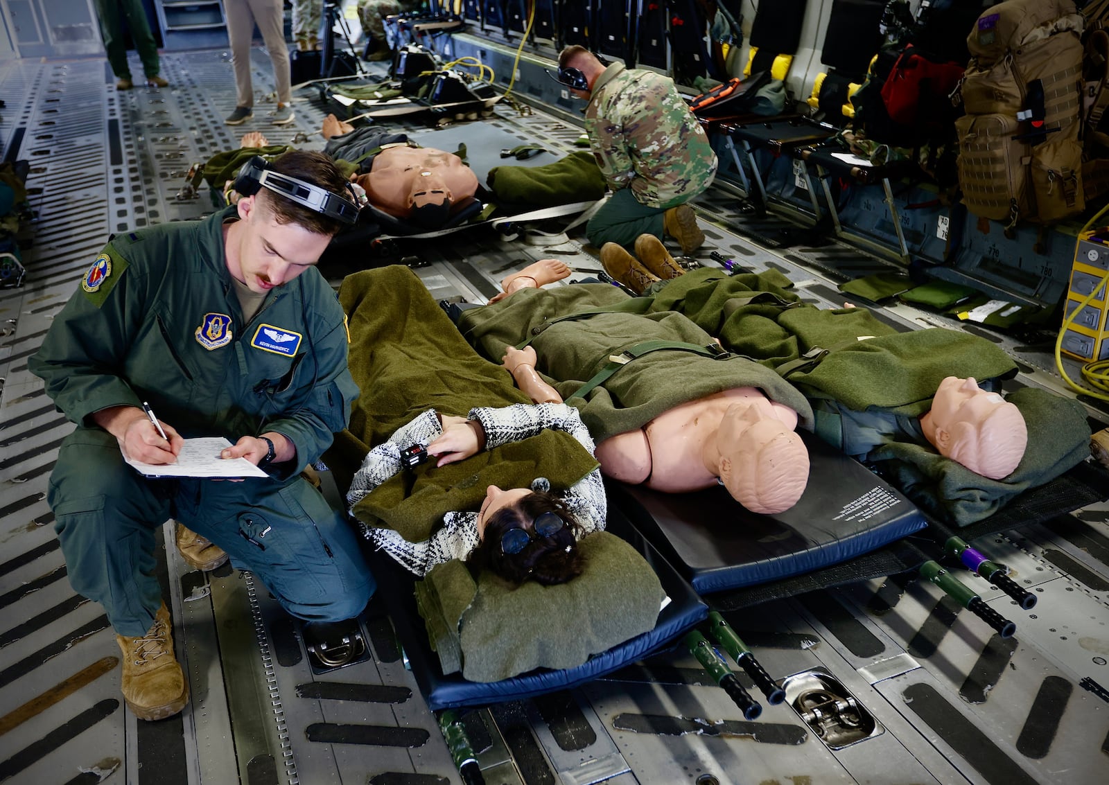 1 Lt. Kevin Mankiewicz, Flight Nurse, demonstrates the care injured people would receive during a mock evacuation drill at Wright Patterson Air Force Base Wednesday, October 16, 2024 on a C-17 Globemaster III. MARSHALL GORBY\ STAFF