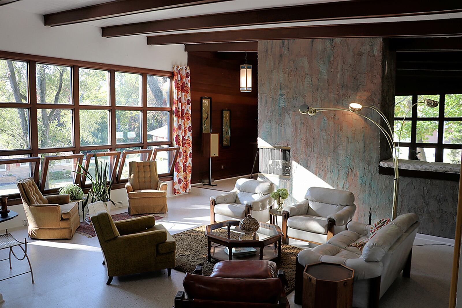 Upon entering, the space opens with a vaulted ceiling with shiplap accents and rich wood beams, which complements the wood-framed picture window. Rich paneled walls provide accents within the formal living room. A stucco fireplace has texture and divides the living room from the dining room. CONTRIBUTED PHOTO BY KATHY TYLER