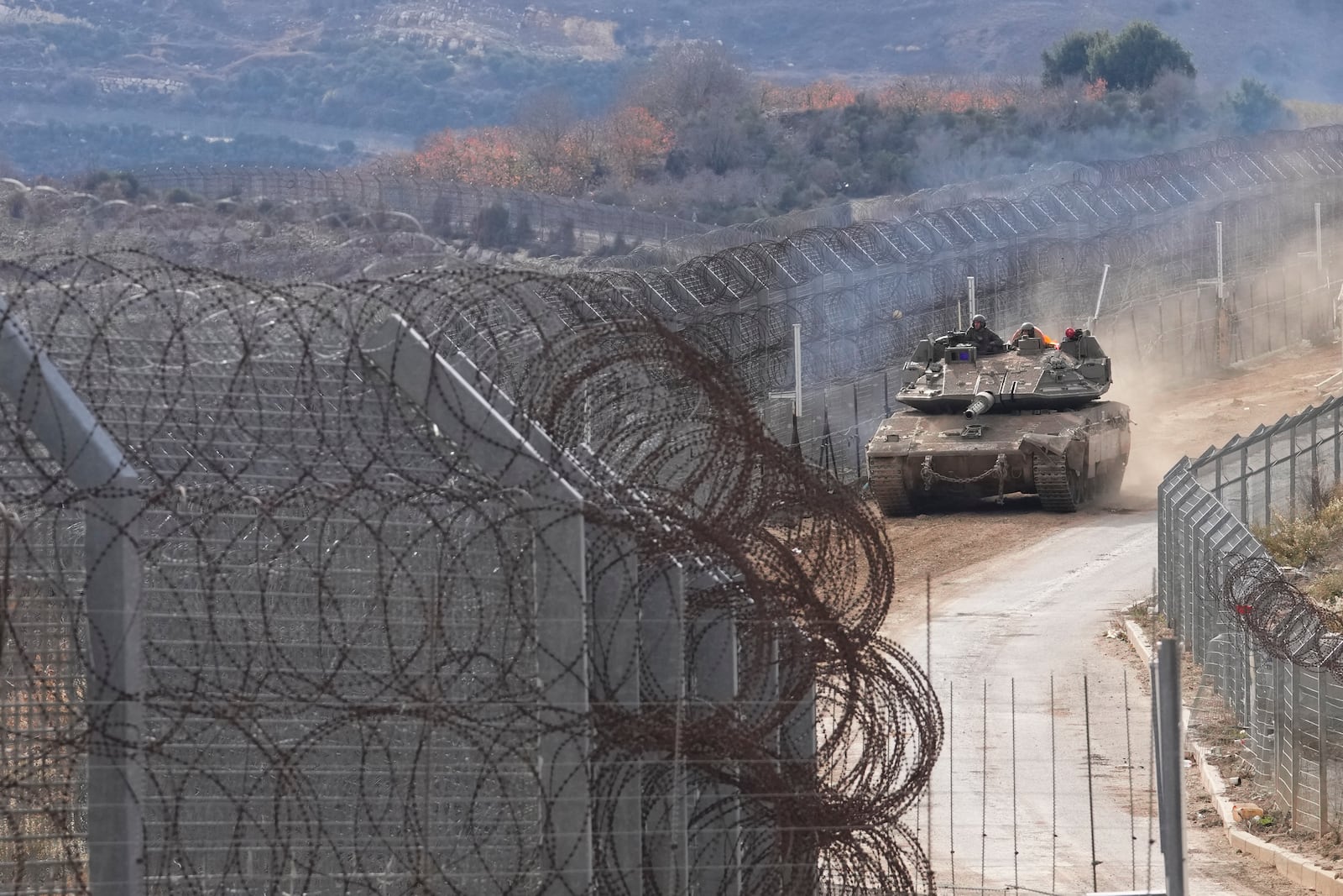 An Israeli army tank maneuvers near the so-called Alpha Line that separates the Israeli-annexed Golan Heights from Syria, in the town of Majdal Shams, Wednesday, Dec. 11, 2024. (AP Photo/Matias Delacroix)