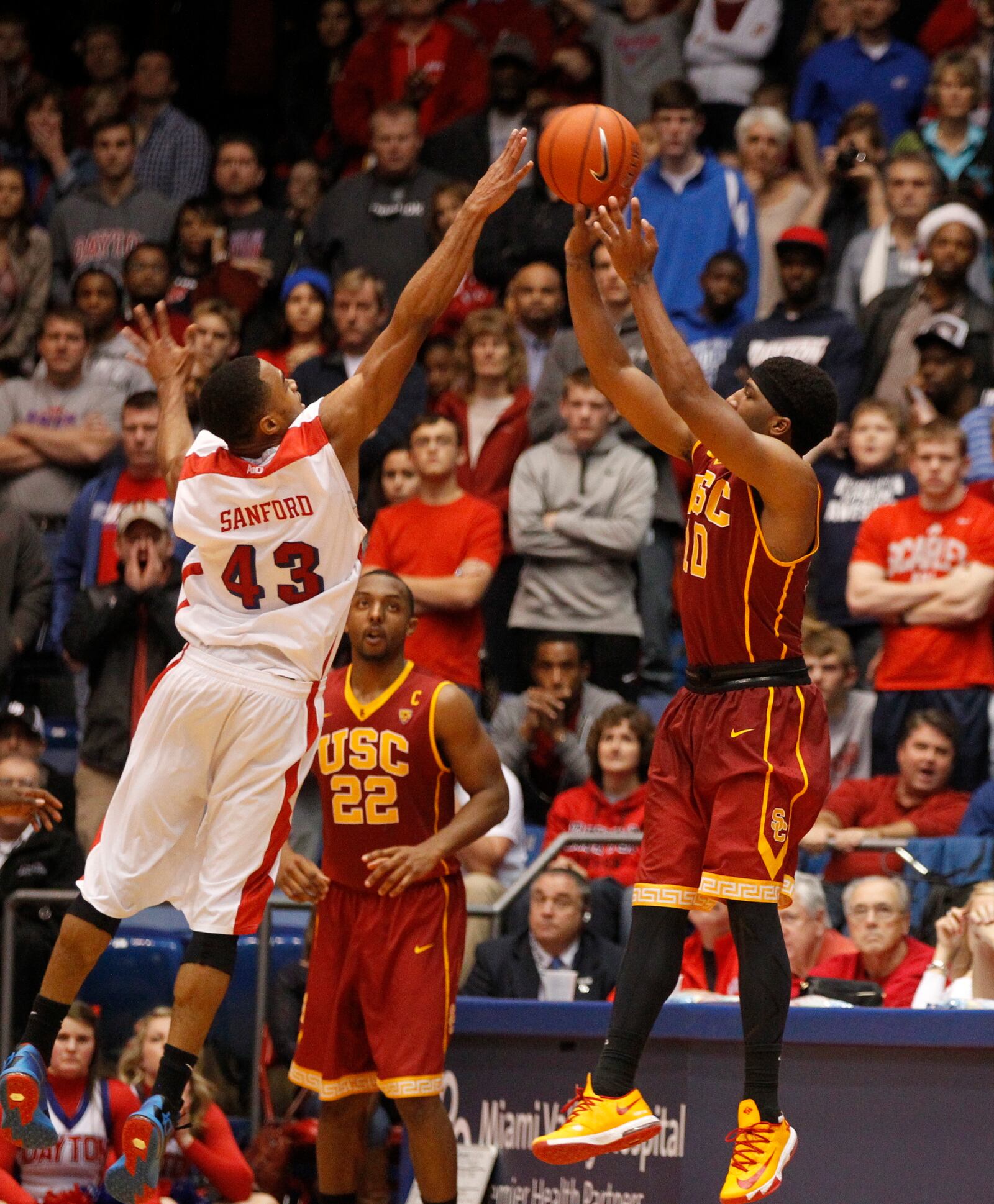 Southern California's Pe'Shon Howard hits the game-winning 3-pointer at the buzzer in overtime as Dayton guard Vee Sanford defends on Sunday, Dec. 22, 2013, at UD Arena. David Jablonski/Staff