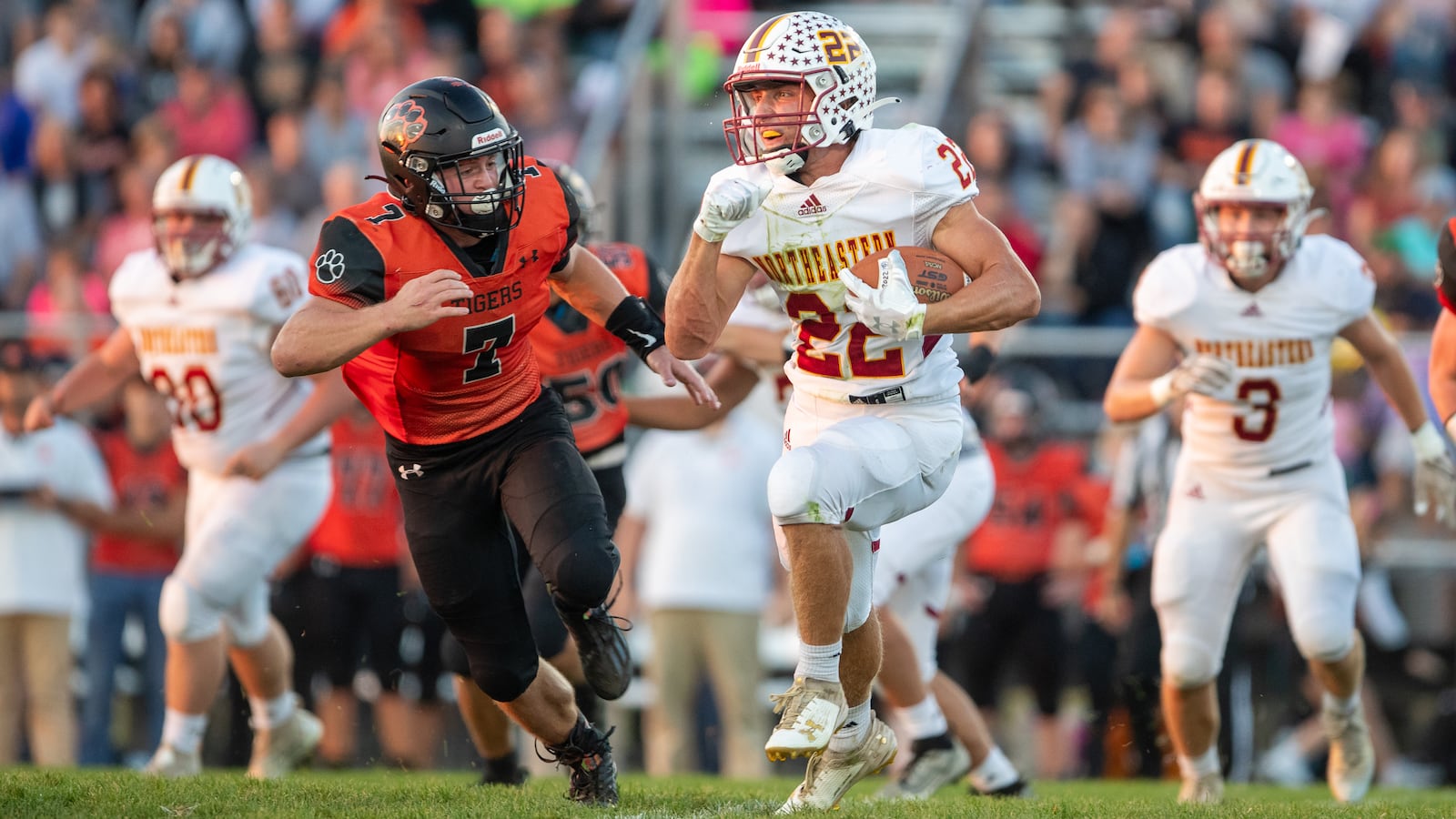 Northeastern High School junior Garrett Chadwell runs past West Liberty-Salem junior Josh Wilcoxon during their game on Friday night at Tiger Stadium in West Liberty. The Tigers won 42-7. CONTRIBUTED PHOTO BY MICHAEL COOPER