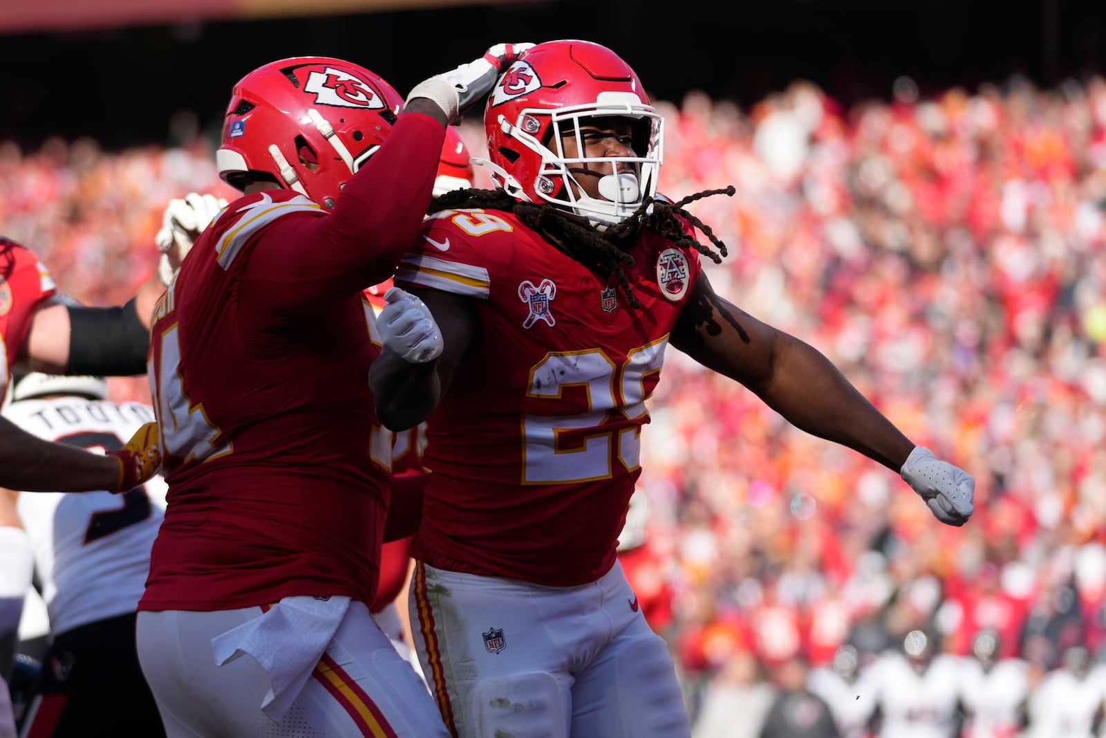 Kansas City Chiefs running back Kareem Hunt, right, celebrates after scoring during the first half of an NFL football game against the Houston Texans Saturday, Dec. 21, 2024, in Kansas City, Mo. (AP Photo/Ed Zurga)