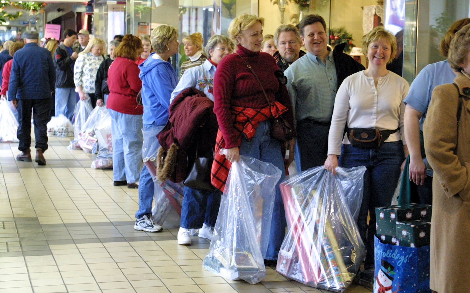 Shoppers wait in line to enter and pay for their purchases at DeClark's Hallmark Gifts and Collectibles at Town and Country Shopping Center in Kettering. The line for the cash registers wound its' way through the store beginning in the hallway outside. Owner Dan DeClark said the store will have over 2,000 transactions and twice that number of people will visit the shop.