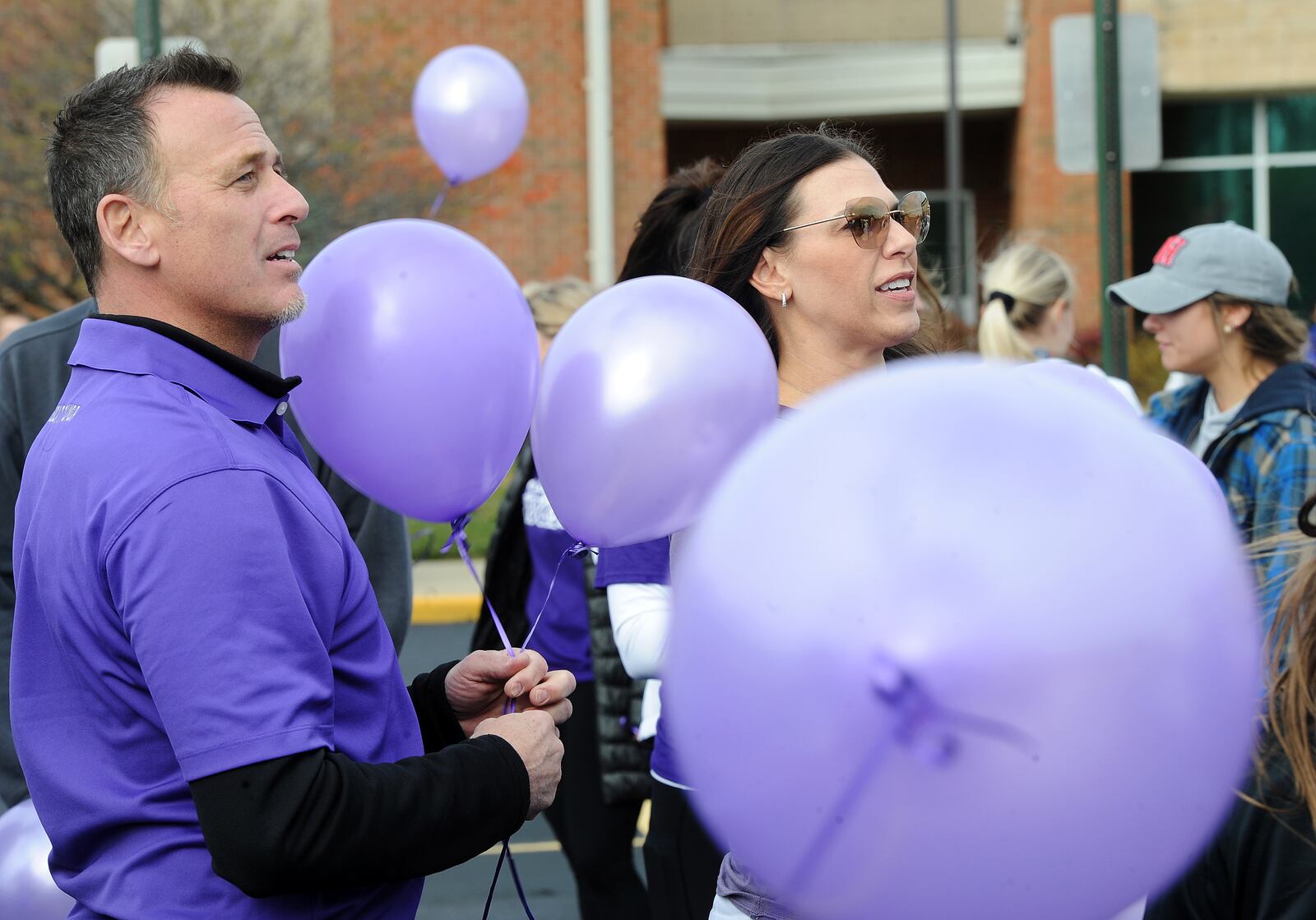 Raymond and Becca Scacchetti took part in a balloon launch Friday, Nov. 12, 2021, at Five Points Elementary in Springboro for their daughter Reagan, a fourth-grader battling a rare form of brain cancer. Reagan's family and friends joined staff and students to celebrate the balloon launch. Over 200 purple balloons were launched. MARSHALL GORBY\STAFF