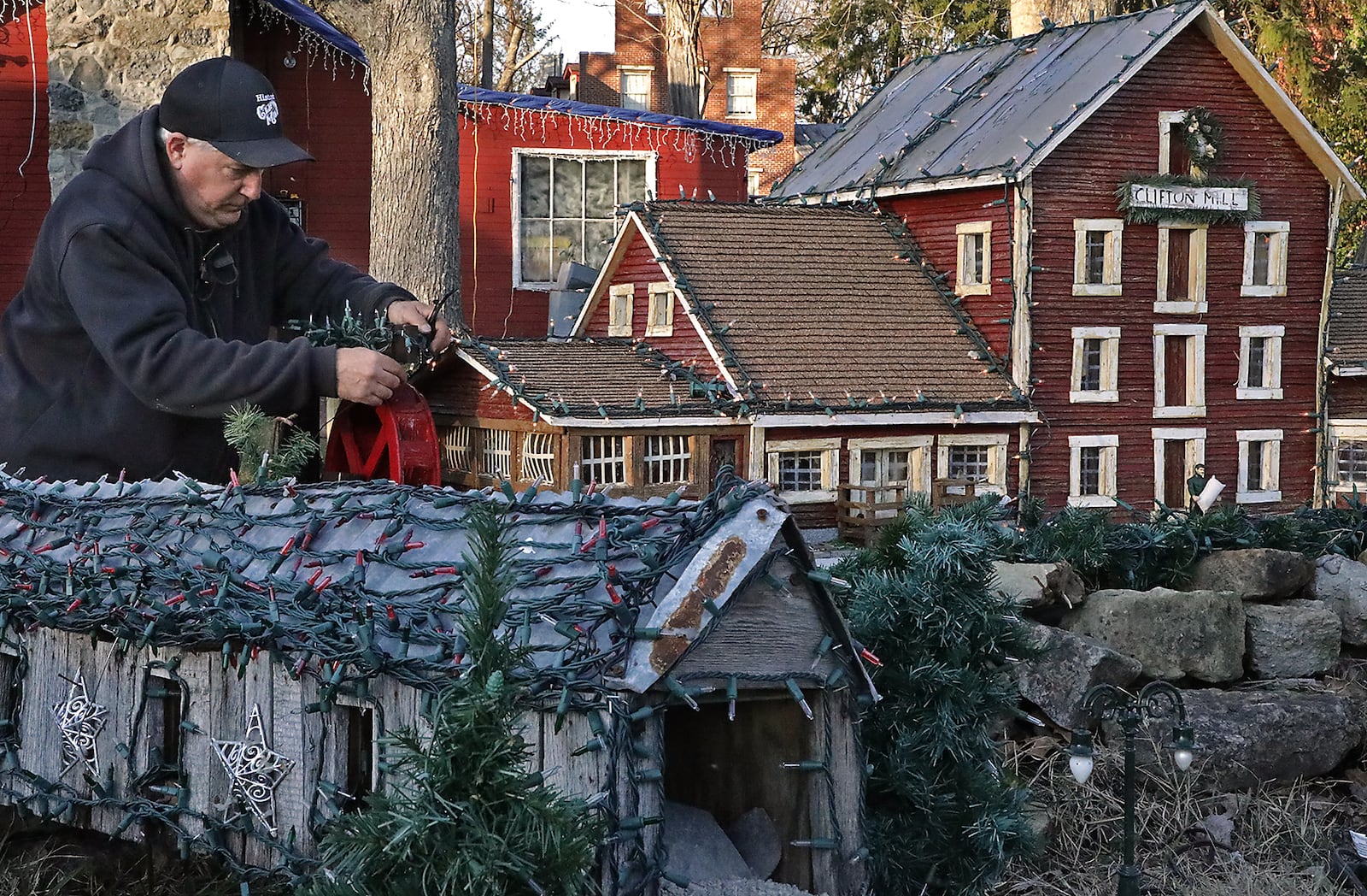 Anthony Satariano, the owner of Clifton Mill, puts lights on a miniature Clifton Mill Monday as he and his crew work to get the mill's award winning holiday display finished. Satariano has been decoarting the mill for the holidays for 32 years and the display has grown to include over 4 million lights. The holiday display goes from Nov. 27 to Dec. 30. BILL LACKEY/STAFF