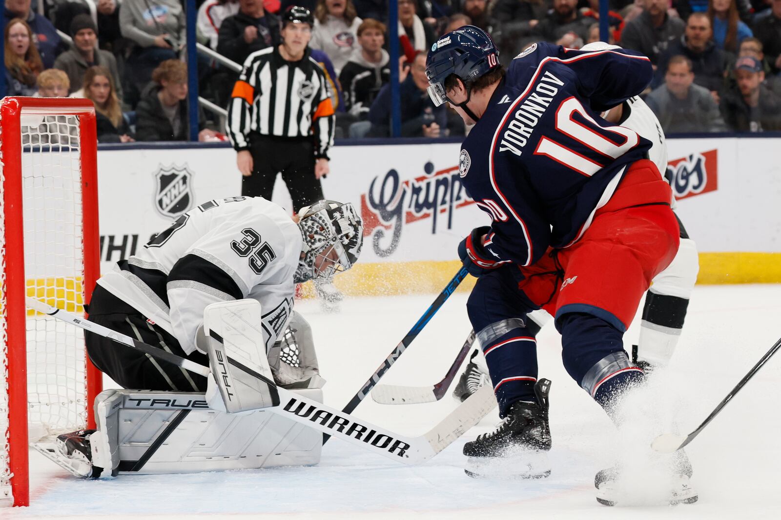 Los Angeles Kings' Darcy Kuemper, left, makes a save against Columbus Blue Jackets' Dmitri Voronkov during the second period of an NHL hockey game Saturday, Jan. 25, 2025, in Columbus, Ohio. (AP Photo/Jay LaPrete)