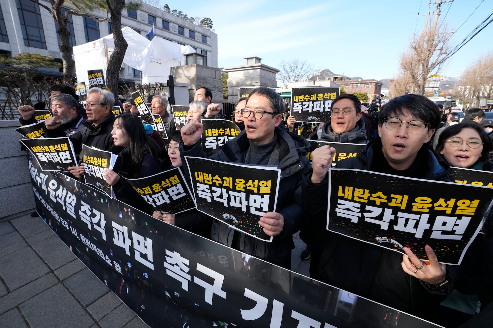 Protesters stage a rally demanding the arrest of impeached South Korean President Yoon Suk Yeol outside of the Constitutional Court in Seoul, South Korea, Friday, Dec. 27, 2024. The signs read, "Fire the rebellion leader Yoon Suk Yeol immediately." (AP Photo/Ahn Young-joon)