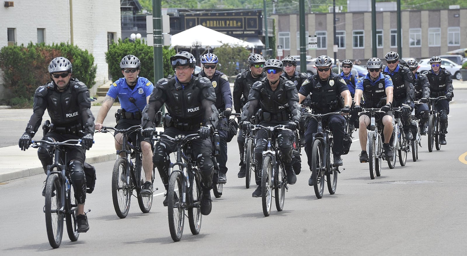 Dayton police ride bikes alongside protesters on Wayne Ave. Saturday to protect them as they march for George Floyd. MARSHALL GORBYSTAFF