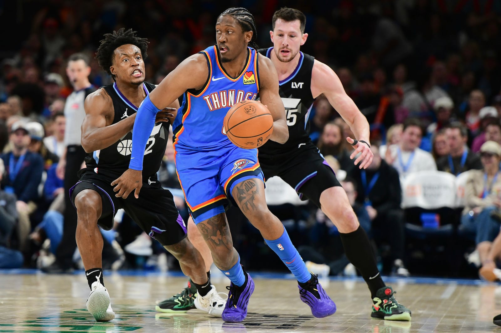 Oklahoma City Thunder forward Jalen Williams, middle, tries to keep the ball away from Utah Jazz guard Collin Sexton, left, and forward Drew Eubanks, right, during the second half of an NBA basketball game, Wednesday, Jan. 22, 2025, in Oklahoma City. (AP Photo/Kyle Phillips)