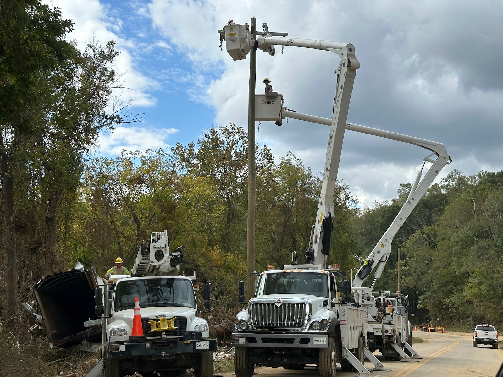 FILE - Contractors for Duke Energy rebuild destroyed electrical lines near the Swannanoa River in Asheville, N.C., Friday, Oct. 4, 2024. (AP Photo/Jeff Amy, File)